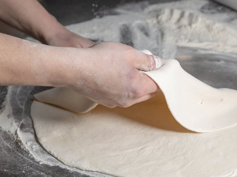 Imos Pizza kitchen with fresh pizza being prepared